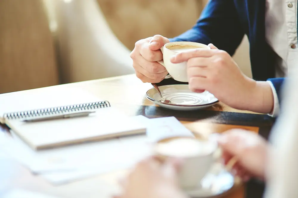 ノートとコーヒーを前にした対話の場面